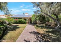 Charming single-story home with lush landscaping, solar panels, and a welcoming walkway at 8637 E Appaloosa Trl, Scottsdale, AZ 85258