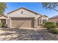 Charming single-story home featuring a tile roof, neutral stucco exterior, and a convenient two-car garage at 16232 W Montoya Dr, Surprise, AZ 85374