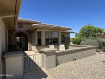 Charming home exterior featuring a cozy front patio with seating and desert landscaping at 19058 N Aztec Point Dr, Surprise, AZ 85387