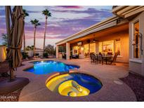 Inviting pool and spa with swaying palm trees create a serene backyard oasis for relaxation and entertainment at 22318 N Pico Ct, Sun City West, AZ 85375
