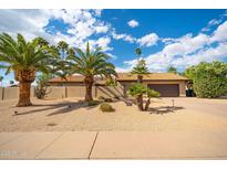 Stunning single-story home with desert landscaping, mature palm trees, and a two-car garage at 302 E Acapulco Ln, Phoenix, AZ 85022