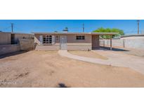 Charming single-story home with a tan brick exterior, desert landscaping, and covered parking at 3946 W Monte Vista Rd, Phoenix, AZ 85009