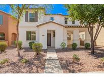 Inviting two-story home featuring a well-manicured front yard with desert landscaping and neutral tones at 4149 E Devon Dr, Gilbert, AZ 85296