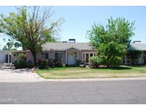 Charming single-story home featuring lush landscaping, a well-manicured lawn, and a welcoming front entrance at 717 E State Ave, Phoenix, AZ 85020