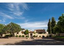 Luxurious estate showcasing grand architecture, lush landscaping, and gated entry under a bright blue sky at 7525 N Shadow Mountain Rd, Paradise Valley, AZ 85253