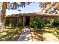 Charming single-story brick home featuring mature trees, a well-maintained lawn, and welcoming front entrance at 930 E Page St, Gilbert, AZ 85234