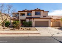 Charming two-story home features a neutral color palette and a well-maintained front yard at 10313 W Windsor Ave, Avondale, AZ 85392