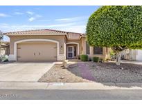 Inviting single-story home with desert landscaping, tiled roof, and attached two-car garage at 11550 W Mule Deer Ct, Surprise, AZ 85378