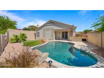 Inviting backyard features a sparkling pool with rock accents and lush landscaping at 13614 N 12Th Way, Phoenix, AZ 85022