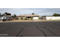 Charming single-story home with a well-maintained front yard and two-car garage at 1404 S Spencer --, Mesa, AZ 85204