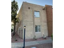 The exterior of this 2-story building features stucco walls, a streetlight and simple landscaping at 2121 W Royal Palm Rd # 2049, Phoenix, AZ 85021