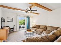 Inviting living room with exposed beam ceiling, ceiling fan and sliding glass doors to the outside at 3314 N 68Th St # 129, Scottsdale, AZ 85251