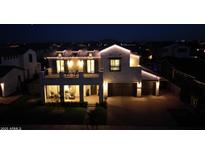 Striking two-story home illuminated at night, featuring a spacious balcony and a two-car garage at 3669 E Boot Track Trl, Gilbert, AZ 85296