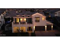 Nighttime aerial shot showcasing the home's striking architectural details and inviting exterior lighting at 3669 E Boot Track Trl, Gilbert, AZ 85296