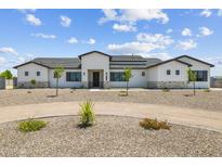 A well-manicured front yard with a circular driveway leads up to a modern home with a stone base and white siding at 3933 E Freeman Ln, San Tan Valley, AZ 85140