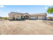 Sprawling home with neutral stucco, tile roof, circular driveway, and a convenient three-car garage at 5221 N Tuthill Rd, Litchfield Park, AZ 85340