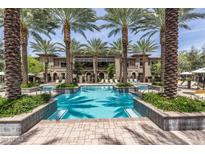 Resort-style pool surrounded by lush landscaping, palm trees, and plenty of seating for relaxation at 6565 E Thomas Rd # 1128, Scottsdale, AZ 85251