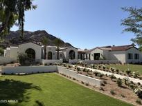 Stunning exterior of white home featuring tile roof, manicured lawn and lush landscaping at 7501 N Eucalyptus Dr, Paradise Valley, AZ 85253