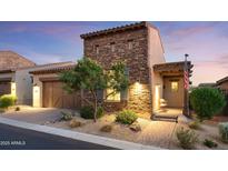 Charming stone-accented home featuring a well-manicured front yard and inviting front porch at 8691 E Eastwood Cir, Carefree, AZ 85377