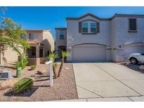 Inviting townhome featuring a two-car garage, desert landscaping and a neutral color palette at 8854 W Aster Dr, Peoria, AZ 85381