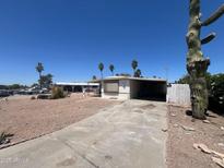 Exterior of a single-story mobile home with a carport and desert landscaping and tall saguaro cactus at 9754 E Sunland Ave, Mesa, AZ 85208