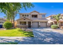 Inviting two-story home featuring a three-car garage, charming balcony, and a well-manicured front yard at 10517 W La Reata Ave, Avondale, AZ 85392