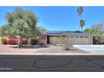 Charming single-story home with a well-maintained yard, desert landscaping, and solar panels on the roof at 1220 E Avenida Ellena St, Casa Grande, AZ 85122