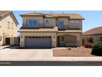 Two-story home showcasing a tile roof, neutral stucco, and a two-car garage at 12209 W Washington St, Avondale, AZ 85323