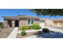 Charming single-story home featuring a tile roof, arched entryway, and vibrant yellow flowering bushes in the front yard at 20838 E Vía De Arboles --, Queen Creek, AZ 85142