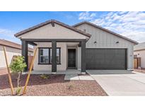 Charming single-story home featuring a covered porch, dark-colored accents, and desert-friendly landscaping at 23385 W Burton Ave, Buckeye, AZ 85326