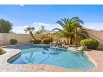 Inviting backyard pool with lush tropical landscaping and rock waterfall feature at 300 W Windsor Dr, Gilbert, AZ 85233
