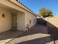 Exterior shot of a home's gravel backyard featuring a stucco wall and greenery at 7232 W Zak Rd, Phoenix, AZ 85043
