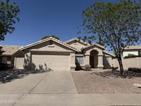 Charming single-story home featuring a two-car garage, low-maintenance landscaping, and a tile roof at 7266 E Monte Ave, Mesa, AZ 85209