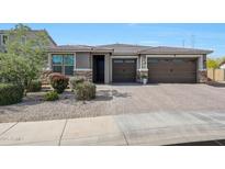 Charming home featuring desert landscaping, a brick driveway, and a convenient three-car garage at 7512 W Warner St, Phoenix, AZ 85043
