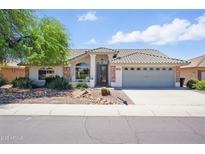 Charming single-story home features a desert landscape, covered entry, and a two-car garage at 11059 E Kilarea Ave, Mesa, AZ 85209