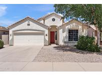 Charming single-story home with a two car garage, red door, desert landscaping and neutral colored stucco at 146 E Rock Wren Dr, San Tan Valley, AZ 85143
