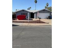 Charming single-story home with a manicured front yard and a convenient two-car garage in a quiet neighborhood at 1553 E Flower Cir, Mesa, AZ 85204