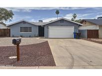 Charming single-story home featuring a two-car garage, well-maintained yard, and desert landscaping at 1553 E Flower Cir, Mesa, AZ 85204