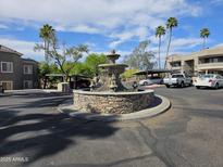 Beautiful water fountain feature in community with desert landscaping, palm trees, and covered parking at 1720 E Thunderbird Rd # 2087, Phoenix, AZ 85022