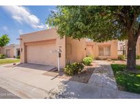 Charming single-story home featuring a two-car garage and a neatly landscaped front yard with mature trees at 17224 N Zuni Trl, Surprise, AZ 85374