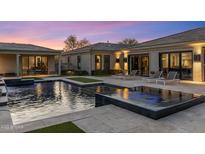 Inviting pool area with luxurious lounge chairs and elegant outdoor lighting at dusk at 26099 N 88Th Way, Scottsdale, AZ 85255