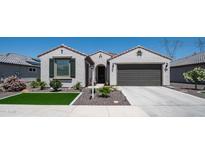 Charming single-story home featuring a well-maintained front yard, a two-car garage, and desert landscaping at 27636 W Runion Dr, Buckeye, AZ 85396