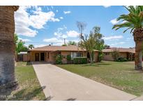 Charming single-story home with a long driveway and a well-maintained lawn at 2913 E Earll Dr, Phoenix, AZ 85016