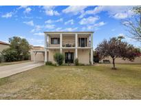 Two-story home featuring a beautiful facade with a second story balcony and well-manicured lawn at 55 E Pierson St, Phoenix, AZ 85012