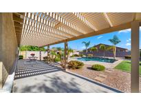 Inviting backyard with a covered patio area and a sparkling pool surrounded by lush landscaping at 6602 S Constellation Way, Gilbert, AZ 85298
