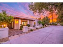 Charming home exterior showcasing a covered entryway, brick walkway and beautiful landscaping at sunset at 6831 E Presidio Rd, Scottsdale, AZ 85254