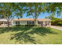 Charming single-story home with lush front yard, mature trees and inviting curb appeal at 1020 E Vermont Ave, Phoenix, AZ 85014