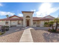 Inviting home featuring a well-manicured yard, tiled roof, and a charming arched entryway at 12899 W Pasadena Ave, Litchfield Park, AZ 85340