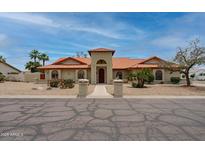 Charming single-story home with a red tile roof, arched windows, and meticulously landscaped front yard at 12899 W Pasadena Ave, Litchfield Park, AZ 85340