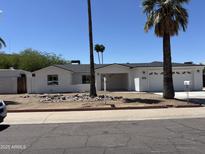 Charming single-story home featuring a two-car garage and an open carport in a sunny neighborhood at 1423 W Joan De Arc Ave, Phoenix, AZ 85029